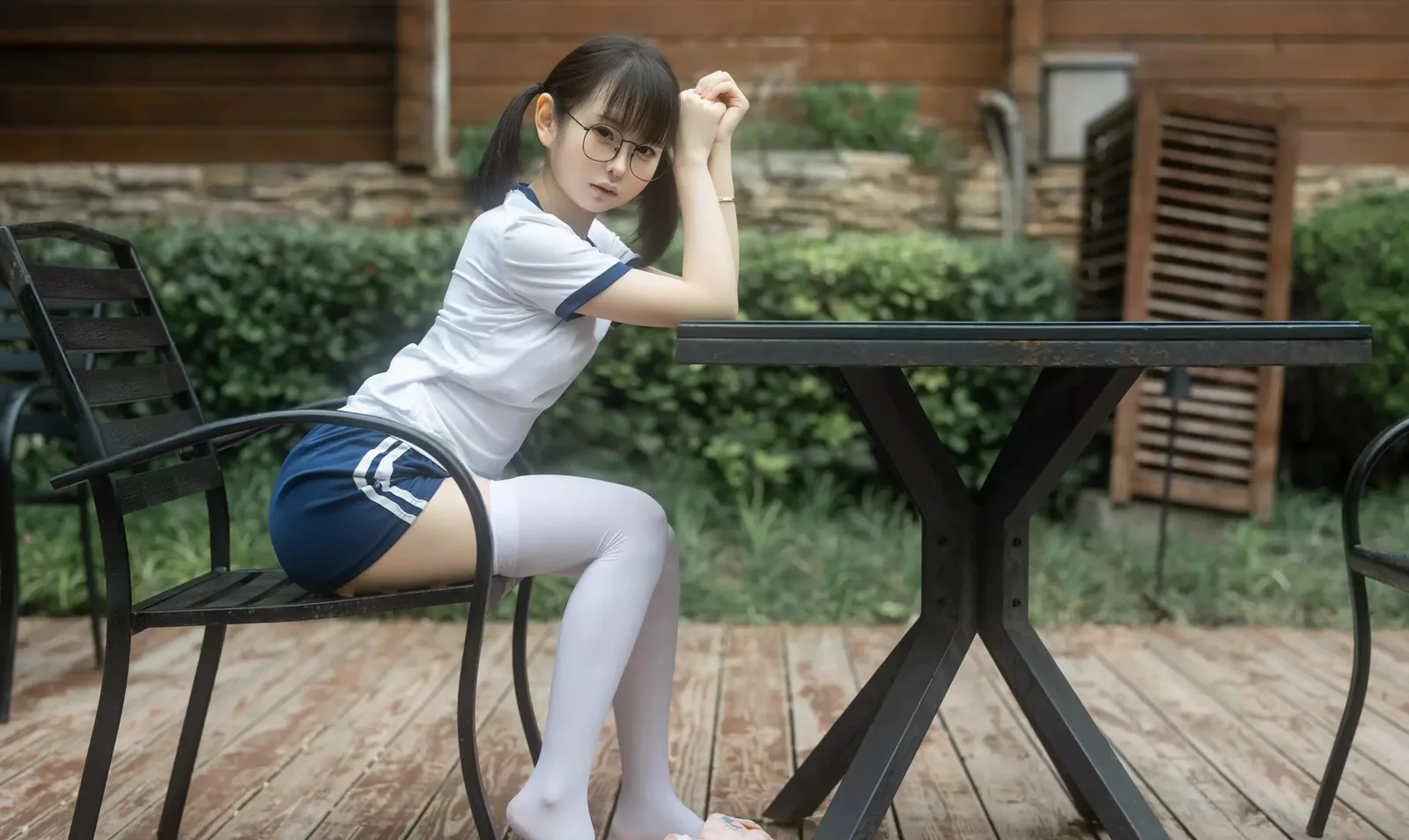 幼水铃衣,白色运动上衣深色短裤人物在户外长椅旁侧坐 幼水铃衣,白色运动上衣深色短裤人物在户外长椅旁侧坐