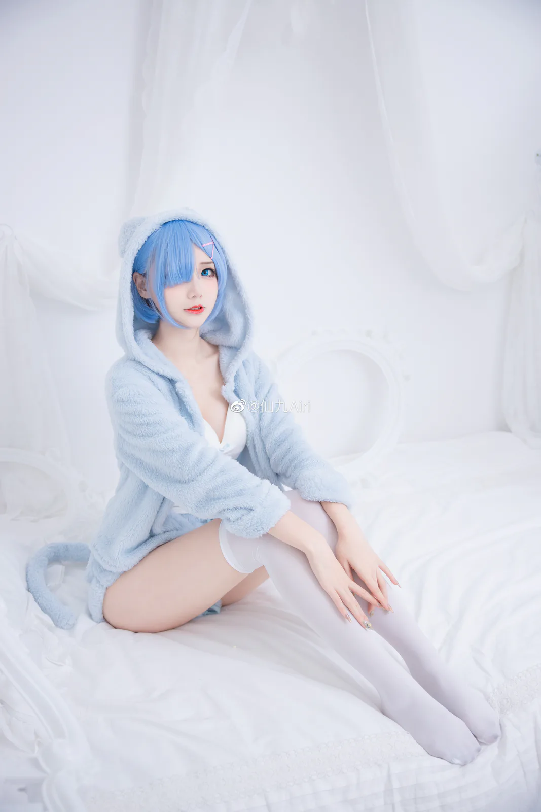 仙九Airi蓝色短发戴粉色发夹,穿浅蓝毛绒帽服坐在白色床面上,双手置于膝前 仙九Airi蓝色短发戴粉色发夹,穿浅蓝毛绒帽服坐在白色床面上,双手置于膝前