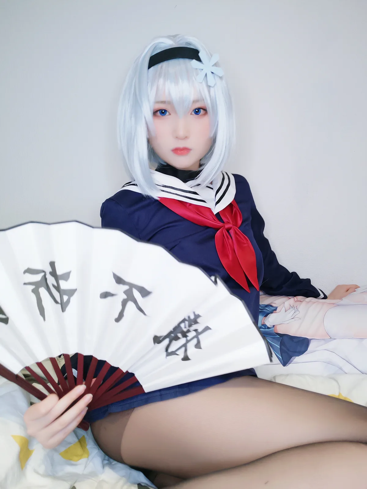 Yuki亭的银白短发水手服造型坐在床边，展开的白色折扇位于前景